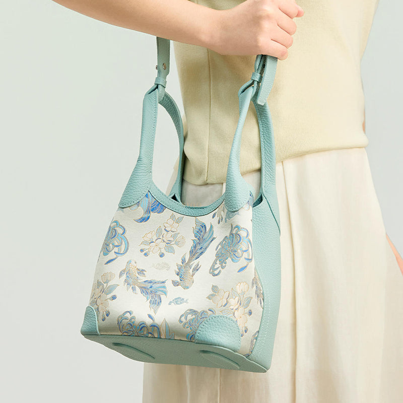 Model carrying the Luxury Shu Brocade Golden Fish & Flower Leather Basket Tote Bag, showing the light blue leather handle, soft structure, and elegant daily styling.