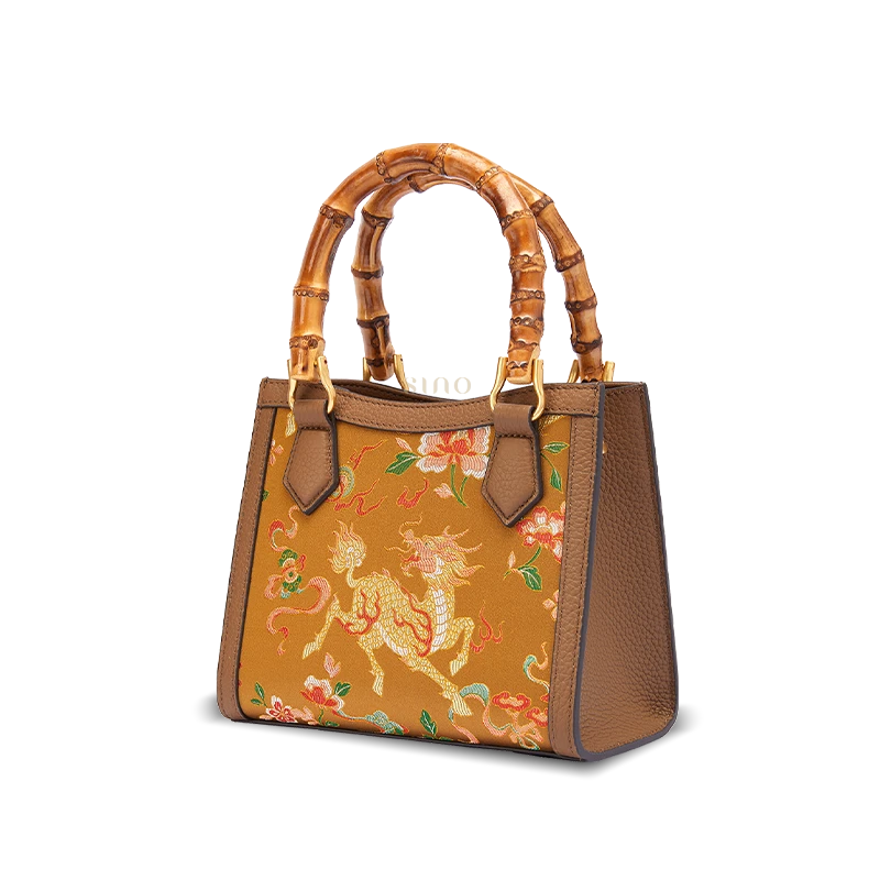 Side view of Shu Brocade Qilin motif bamboo handle handbag with elegant leather frame and tapered structure.