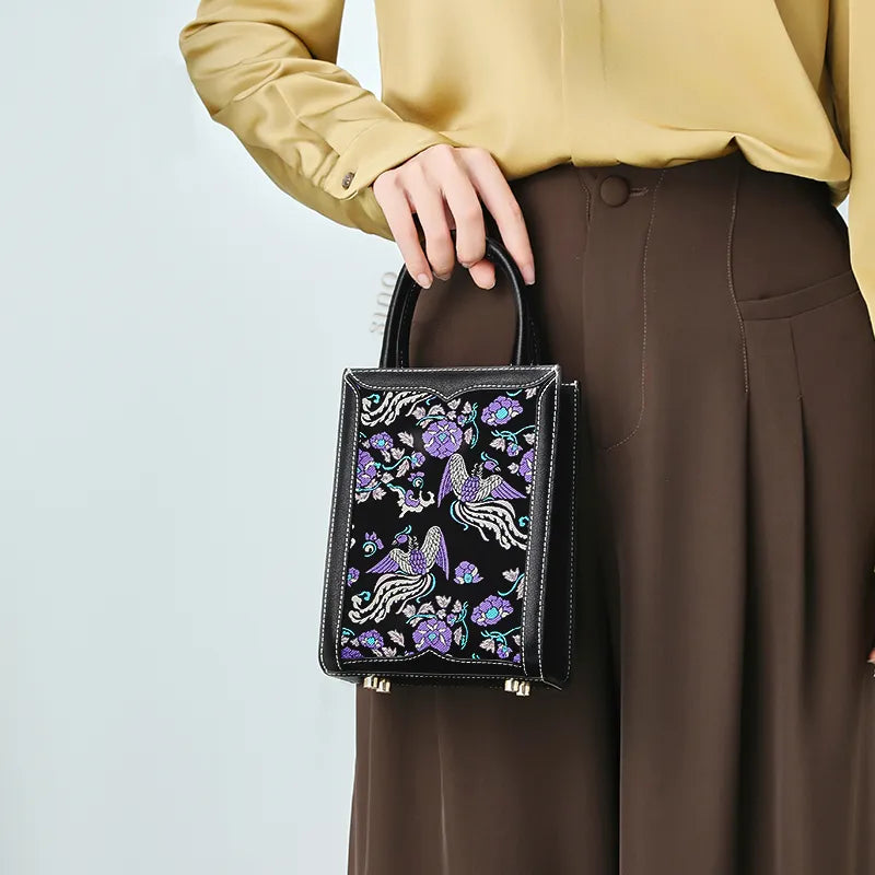 Stylish woman holding the Shu Brocade tote bag at her waist.