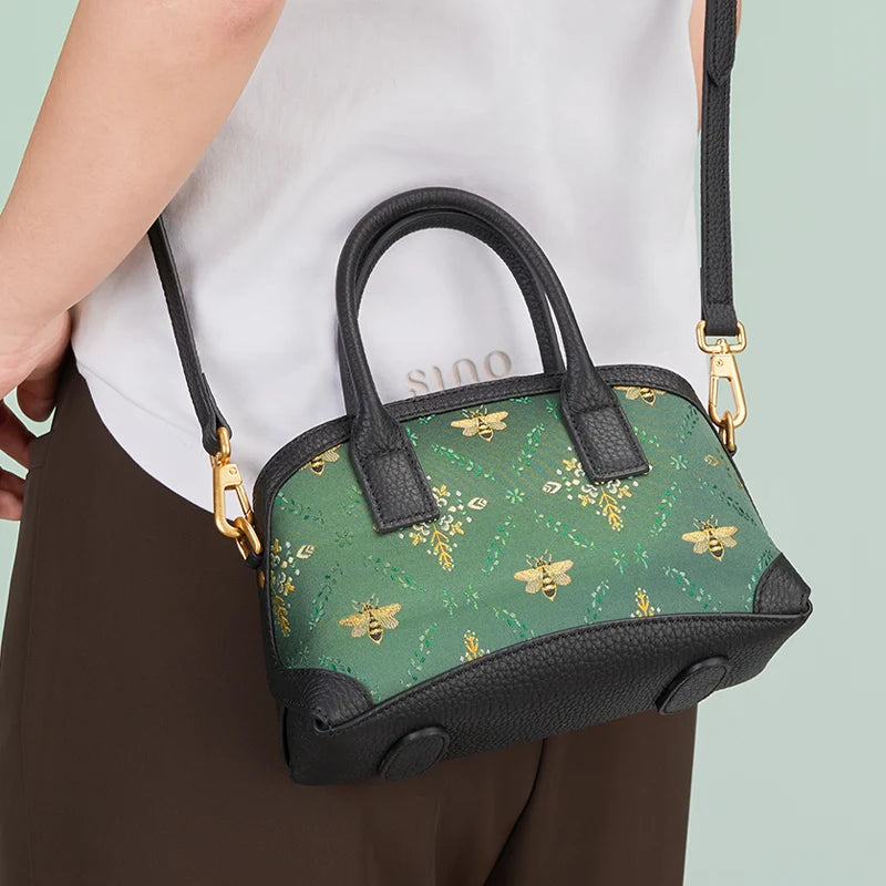 Model wearing the Luxury Shu Brocade Verdant Layers Leather Top Handle Bag with detachable shoulder strap.