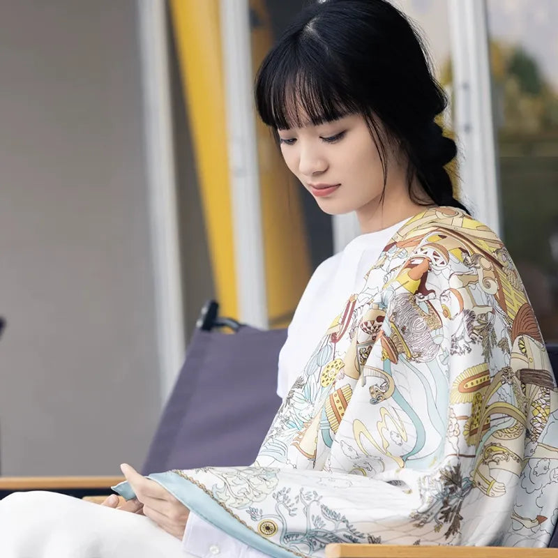 Luxury Nanjing Brocade Six Dynasties Elegance mulberry silk large square scarf styled over the shoulders while seated, highlighting the artistic Chinese-inspired print.