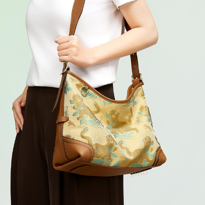 Model carrying the Chinoiserie Song Brocade Brown Tiger Leather Crossbody Bag, highlighting the tiger motif and curved crossbody shape.