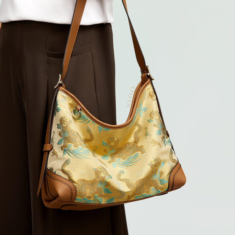 Model wearing the Song Brocade Brown Tiger Leather Crossbody Bag, showing the shoulder strap, brown leather trim, and tiger brocade pattern.