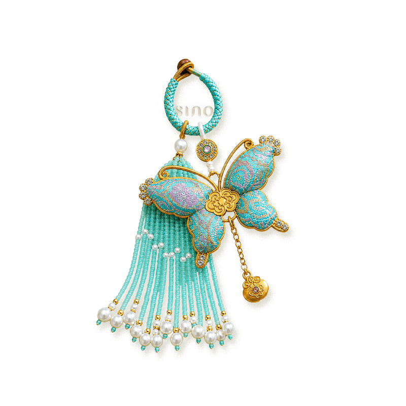 Turquoise Song Brocade butterfly pearl tassel bag charm isolated on a transparent background with pearl-beaded tassels and gold-tone butterfly detailing.