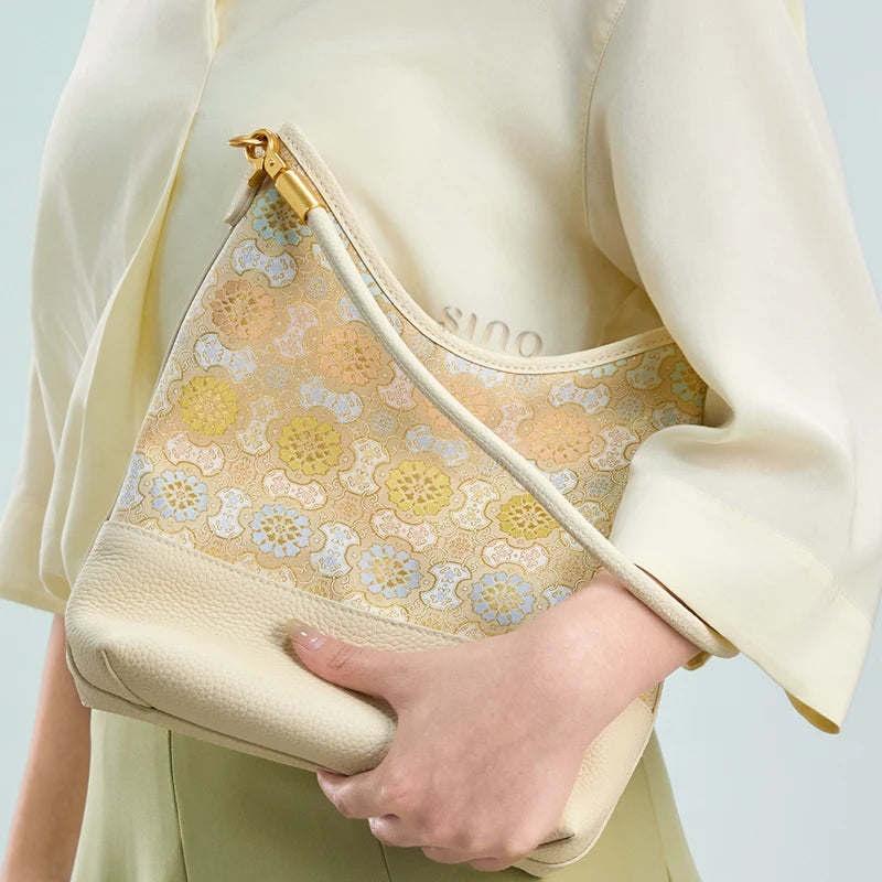 Close-up lifestyle view of a model carrying the Chinoiserie Luxury Song Brocade Ruyi Victory Leather Shoulder Bag.