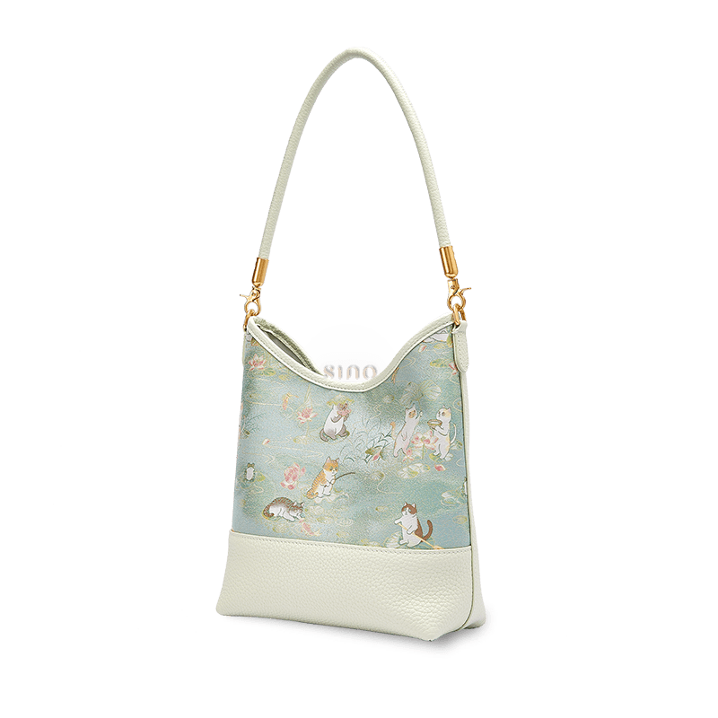 Angled view of a Chinoiserie Springtime Tales shoulder bag crafted from pale green Song Brocade and leather.