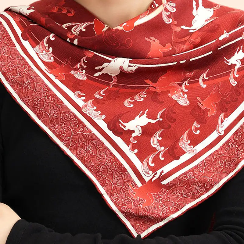 Woman wearing the Steed Across the Tides red Mulberry Silk Square Scarf draped around the neck and shoulders.