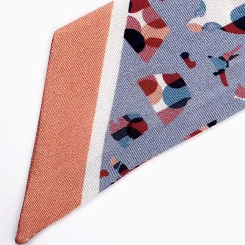 Close-up of the border and colorful artifact motifs on the Suzhou Museum Mulberry Silk Twilly.