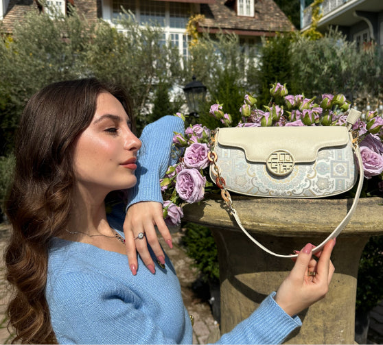 Influencer @takoogelashvili showcases the Octagonal Geometric Brocade Shoulder Bag in white—amidst serene garden blooms.