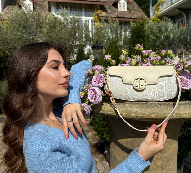 Influencer @takoogelashvili showcases the Octagonal Geometric Brocade Shoulder Bag in white—amidst serene garden blooms.