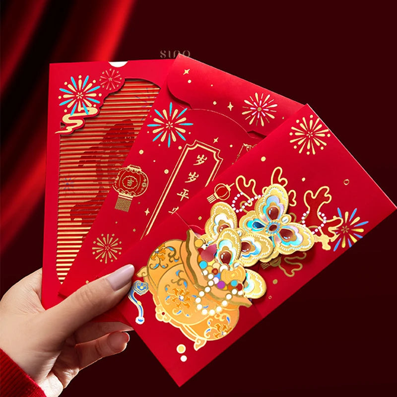 Hand holding three traditional Chinese New Year red envelopes with festive red and gold designs, decorative motifs, and colorful embellishments.