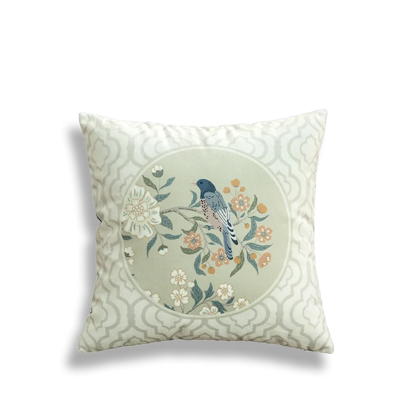 White embroidered pillow with circular birds and flowers.