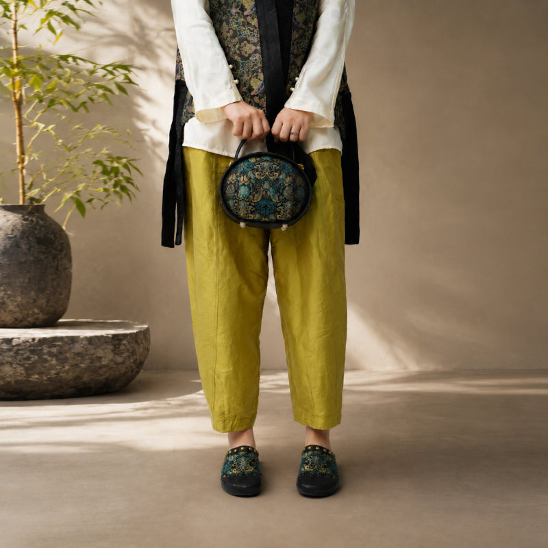 Woman wearing black Song Brocade mules with Chinese-inspired textile craftsmanship.