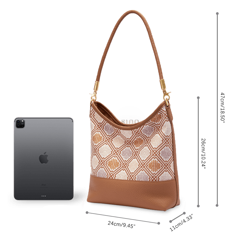 Size and capacity comparison of the Zhuang Brocade Chrysanthemum Meander leather shoulder bag beside a tablet.