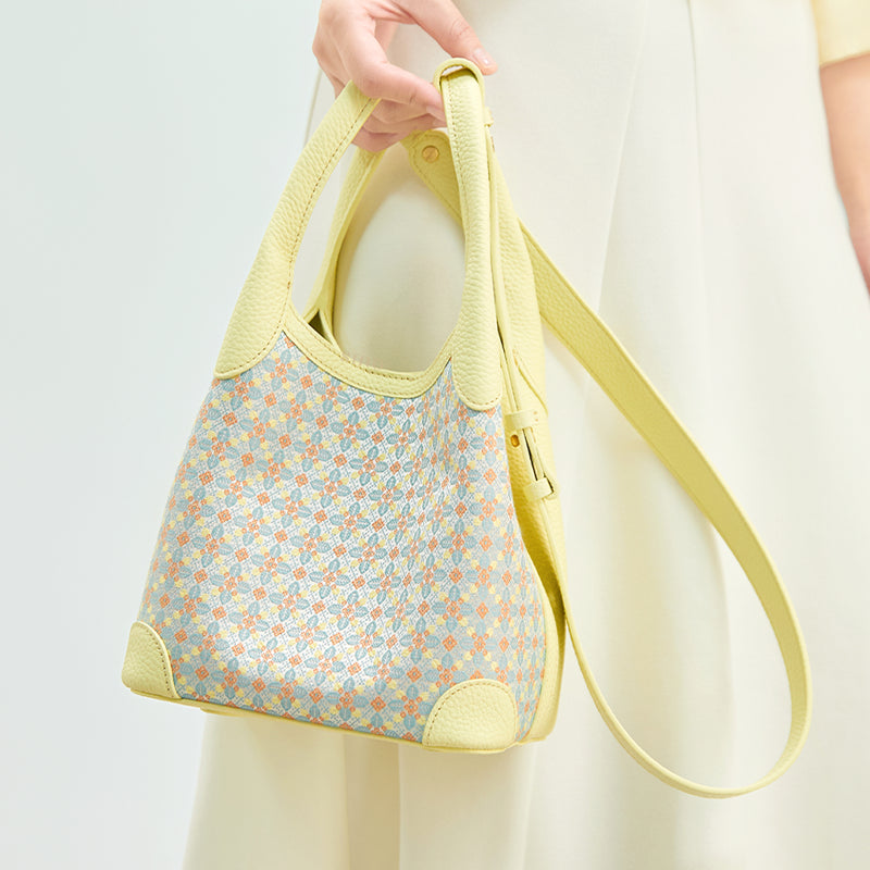 Close-up model view of the Luxury Zhuang Brocade Osmanthus Motif Leather Basket Tote Bag, highlighting the woven osmanthus-inspired motif, leather handles, and adjustable long strap.