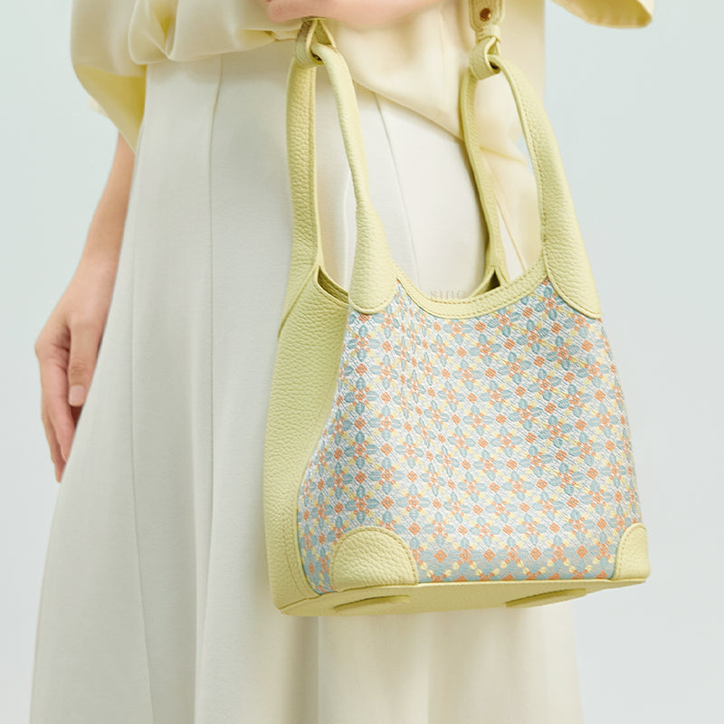 Side model view of the Luxury Zhuang Brocade Osmanthus Motif Leather Basket Tote Bag, featuring the refined brocade body, pale yellow leather side panel, and elegant daily styling.